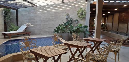 a patio with tables and chairs next to a pool at Tapindaré Hotel in Alto Paraíso de Goiás