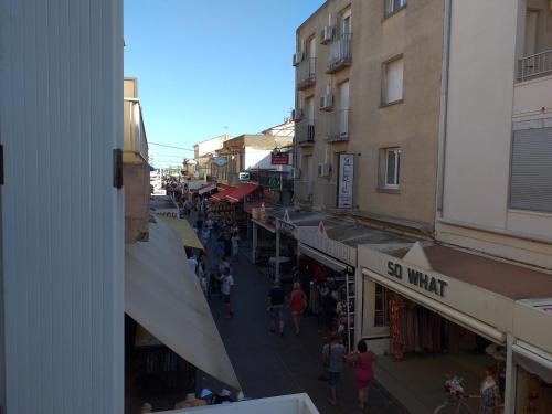 Un groupe de personnes marchant dans une rue avec des bâtiments dans l'établissement Détente, à Valras-Plage