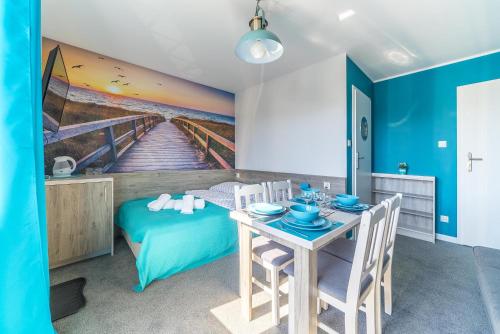 a dining room with a table and a bed at Pokoje Iga in Władysławowo