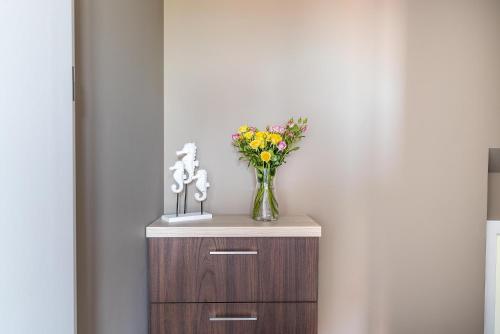 a vase of flowers sitting on top of a cabinet at Pokoje Iga in Władysławowo