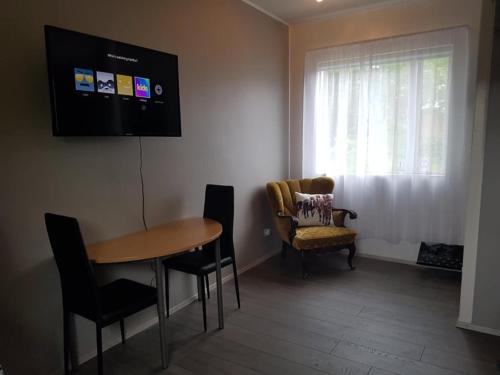 uma sala de estar com uma mesa e cadeiras e uma televisão em Lækjarbakki 11 em Varmahlid