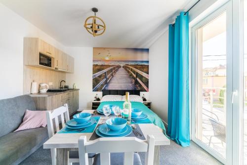 a living room with a dining room table and a kitchen at Pokoje Iga in Władysławowo