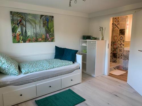 Habitación pequeña con cama y nevera. en Greenhome, en Weil am Rhein