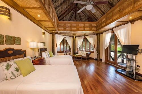 - une chambre avec 2 lits et un ventilateur de plafond dans l'établissement Caleton - Ocean View Villa with Pool, Chef, Butler & Maid, à Punta Cana