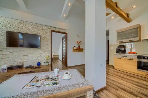 a kitchen with a table and a tv on a brick wall at Apartament Rynek in Tylicz