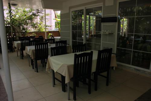 a dining room with tables and chairs and windows at Hotel Vanilla in Fethiye