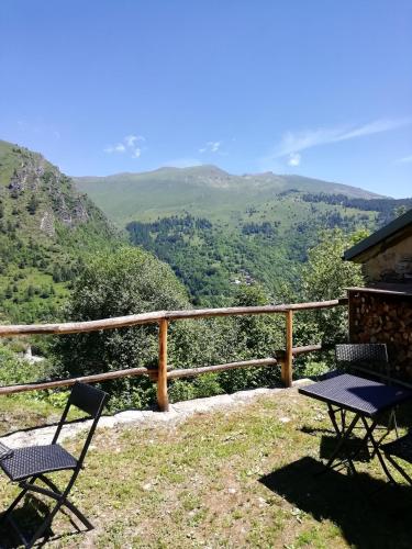 two chairs and a table on top of a mountain at Rota d'Amont in Stroppo