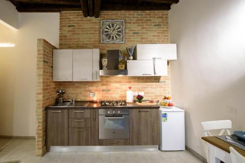 una cucina con armadi in legno e un muro di mattoni di NEW NAVONA ELEGANT APARTMENT a Roma