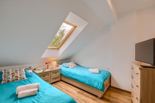 a bedroom with two twin beds and a television at Apartament Rynek in Tylicz