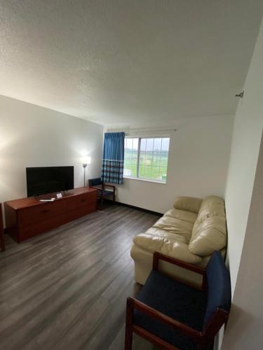 a living room with a couch and a flat screen tv at Super 8 by Wyndham Ida Grove in Ida Grove