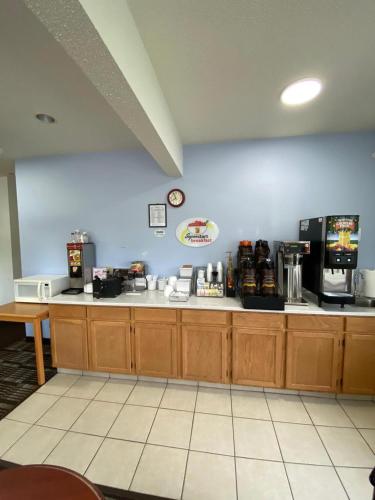a kitchen with wooden cabinets and a counter top at Super 8 by Wyndham Ida Grove in Ida Grove