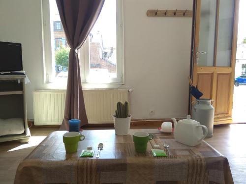 a living room with a table with cups on it at Au Pied Des Remparts in Saint-Valery-sur-Somme