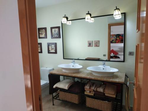 een badkamer met 2 wastafels en een grote spiegel bij casa ximo in L'Aldea