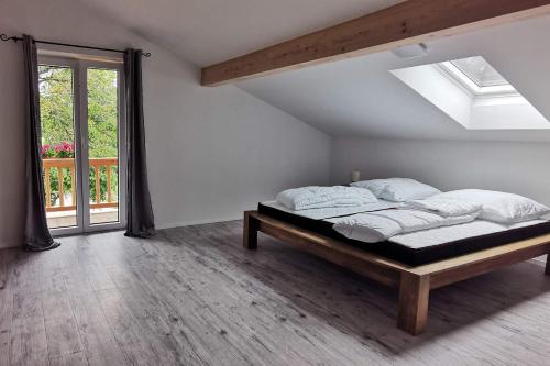een witte slaapkamer met een bed en een raam bij Green Hills Appaloosa Ranch in Waakirchen