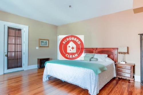 a bedroom with a bed with a sign on it at The Belmont Inn by OYO in Abbeville