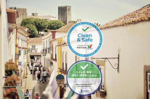 a sign for a clean and safe sign on a street at Rainha Santa Isabel - Óbidos History Hotel in Óbidos