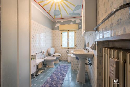 La salle de bains est pourvue de 2 toilettes et d'un lavabo. dans l'établissement Selvatica50 b&b, à Nonantola
