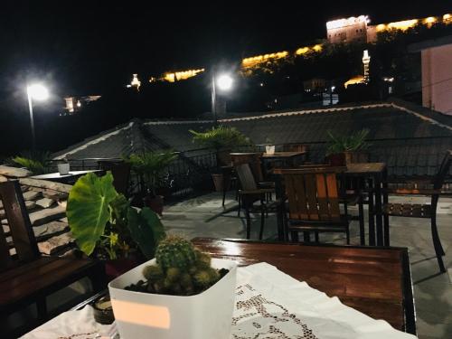 a table with a plant on a patio at night at Kore Guest House in Gjirokastër