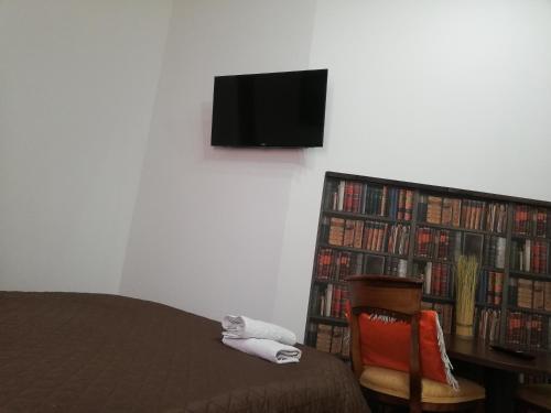 a bedroom with a bed and a book shelf filled with books at Lorf Hostel&Coffee in Krakow