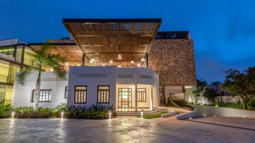 a house with a lit up facade at night at Hotel Las Brisas Merida in Mérida