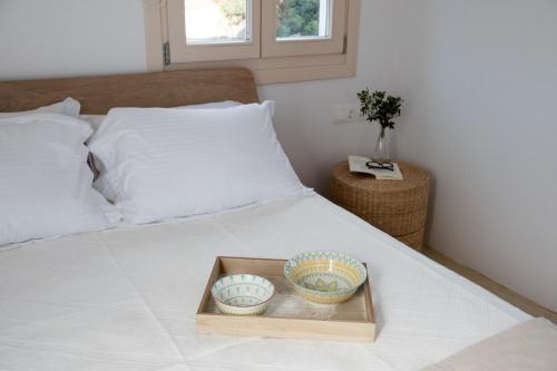 a tray with two baseball bowls on a bed at Almyriki in Mylopotas