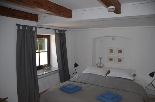 a bedroom with a bed with two blue towels on it at Lykkegård - Glück im ehemaligen Weinkeller in Tönning