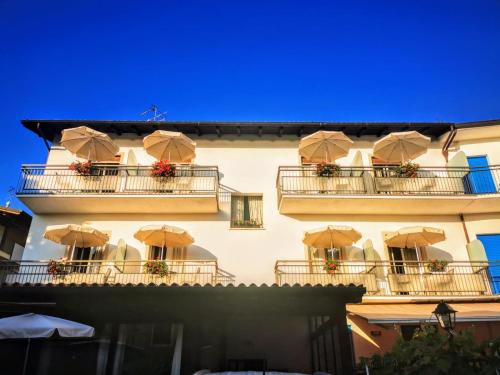 un edificio con sombrillas en los balcones en Albergo Al Pescatore, en Brenzone sul Garda