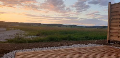 a view of a field with a wooden deck at Paradis Secret Spa in Damprichard