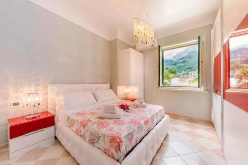 um quarto branco com uma cama e uma janela em Bouganville Holiday house Amalfi em Amalfi