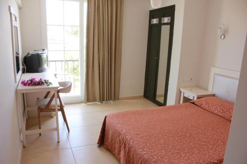 a bedroom with a bed and a table and a window at Hotel Vanilla in Fethiye