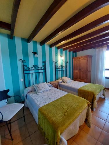 2 camas en una habitación con paredes azules en Casa de Labranza Ría de Castellanos, en Arnuero