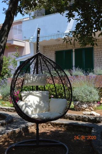 a swing chair with pillows in a yard at Apartment PALATISA in Kožino