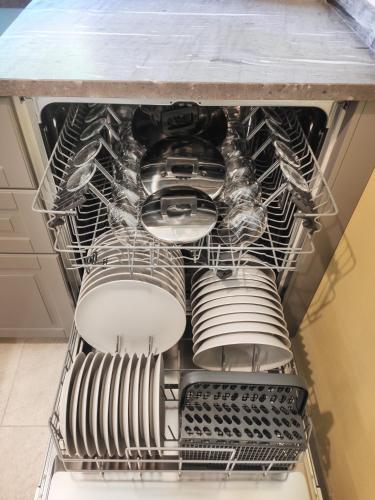 an open dishwasher with dishes in it at Villa Bianca by GardaDoma in Brenzone sul Garda