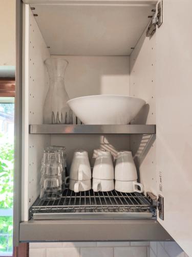 a shelf in a kitchen with a bowl and dishes at Villa Bianca by GardaDoma in Brenzone sul Garda