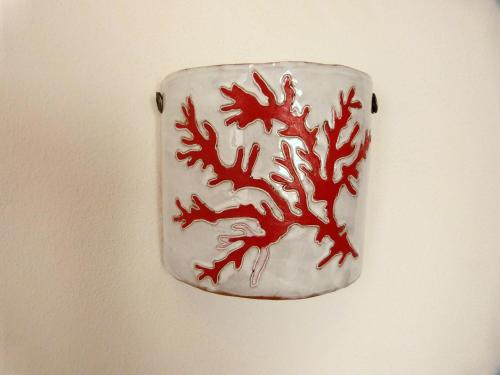 a red and white plate with a dragon on a wall at Clelia's Boutique Rooms & Suites in La Maddalena
