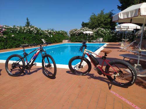 two bikes parked next to a swimming pool at Residence La Casaccia in Venturina Terme