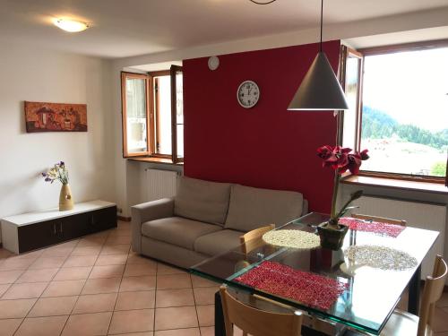 a living room with a couch and a glass table at Appartamento Andalo per famiglie, lontano dal caos in Andalo