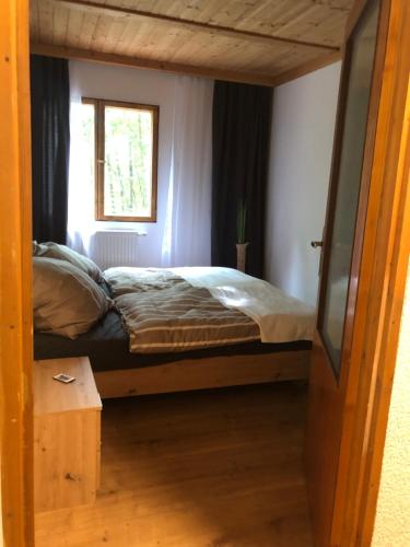 Łóżko w małym pokoju z oknem w obiekcie NEU! Chalet Ilztal w mieście Hutthurm