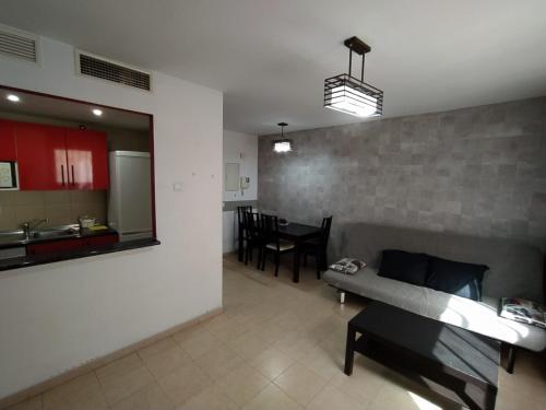 a living room with a couch and a kitchen at Apartamento Eursu Playa in Málaga