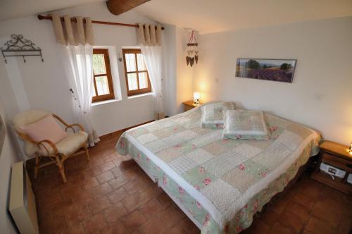 1 dormitorio con 1 cama y 1 silla en Maison Bijoux-de-Provence "Lavande", en Puyméras