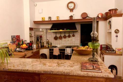 a kitchen with a counter with a clock on the wall at Beautiful country house located 50min from Paris Eiffel Tour - Demeure d'exception à 50min de Paris Tour Eiffel in Hodent