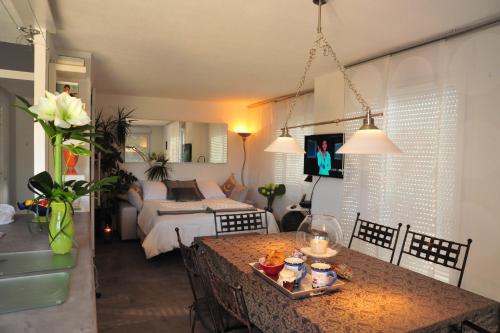 een woonkamer met een eettafel en een slaapkamer bij Magic Moments Appartement in Annecy