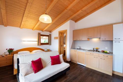 1 dormitorio con cama blanca y almohadas rojas en B & B Apartments Ortlerblick, en Sluderno