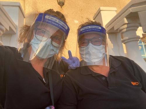 twee vrouwen met gezichtsmaskers en chirurgische maskers bij Apartment El Barco - Las Casas de Aron in Caleta De Fuste