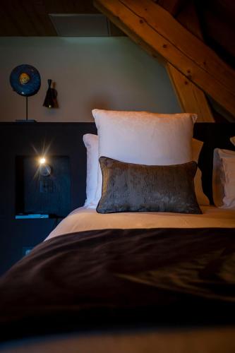 a bedroom with a large bed with white pillows at Hôtel L'Incomparable Aix-Les-Bains in Tresserves