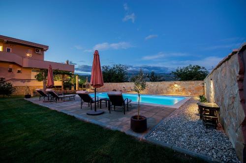 a backyard with a pool and a table and umbrella at Villa Dama in Mostar