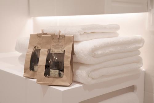 a pile of white towels on a shelf with a bag at NUEVO Katu Kale Apartamentuak CENTRO HISTORICO in Getaria