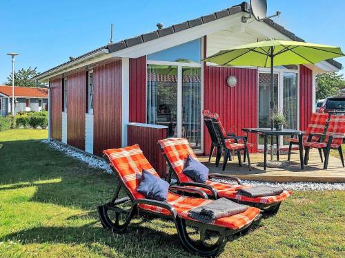 a couple of chairs and an umbrella on a yard at 4 person holiday home in GROEMITZ in Grömitz