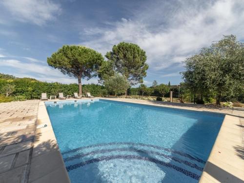une grande piscine avec des chaises et des arbres dans l'établissement Villa in Carpentras with Private Pool, à Carpentras