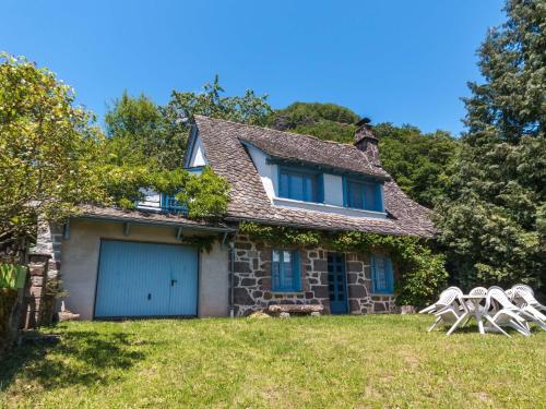ein altes Steinhaus mit zwei weißen Stühlen im Hof in der Unterkunft Beautiful villa 150 m from the beach in Vic-sur-Cère